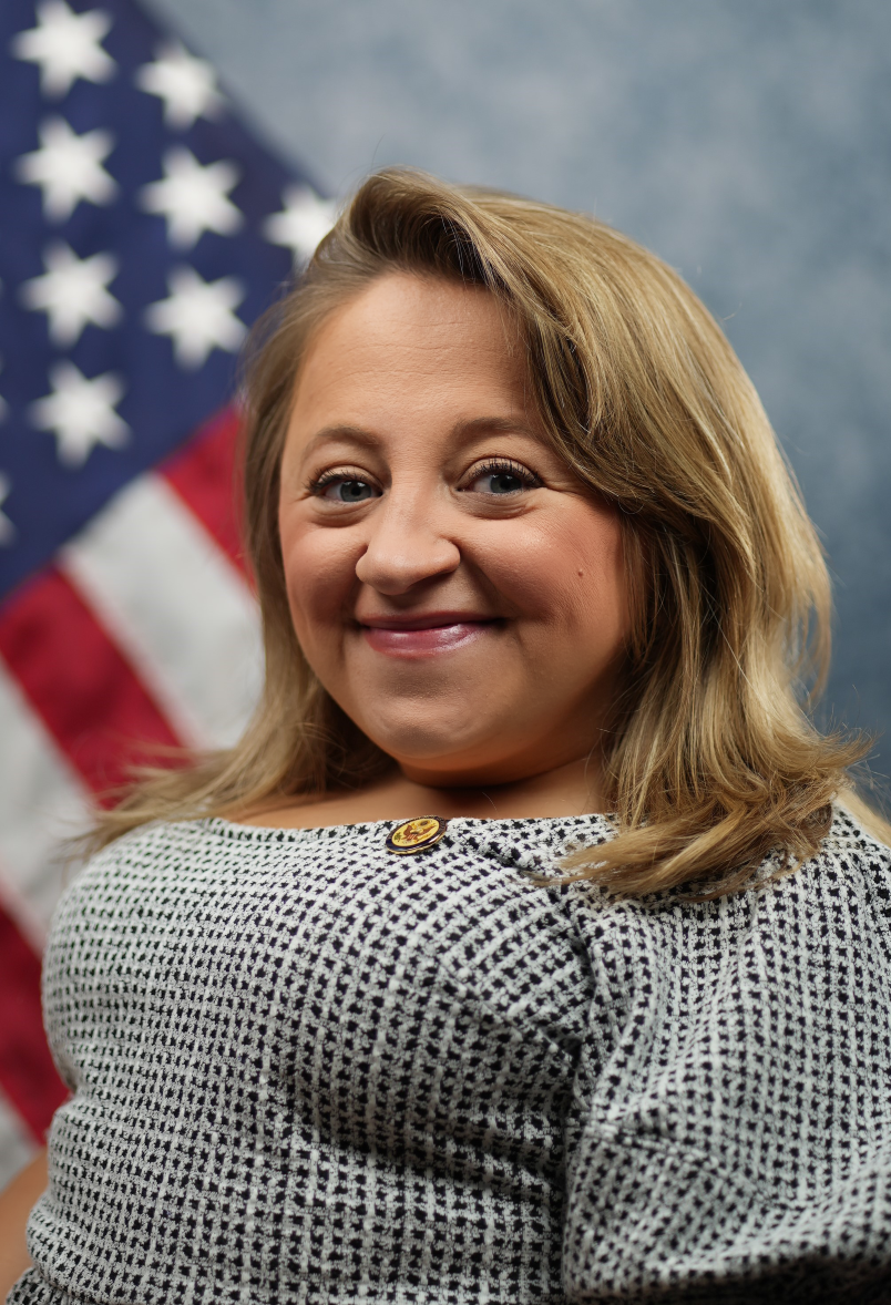 Vice Chair Emily Voorde headshot in front of U.S. flag
